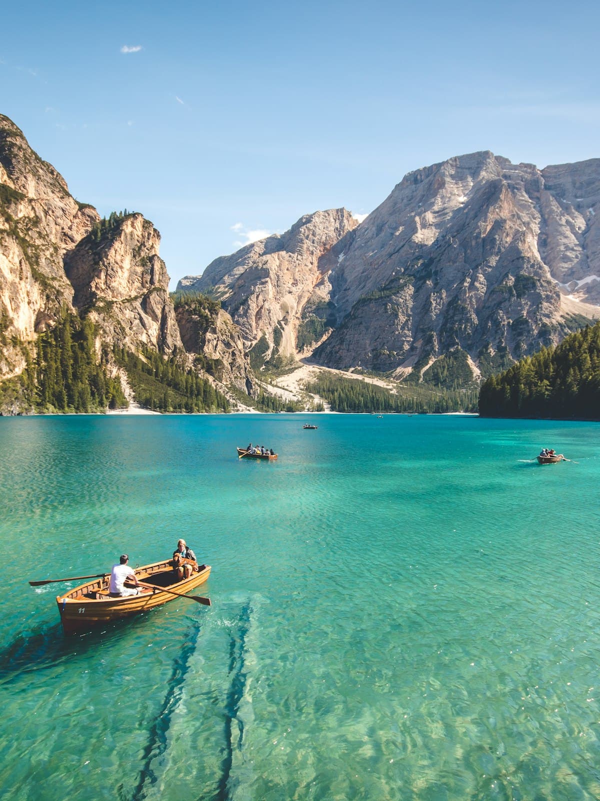 A small boat on a calm turquoise mountain lake