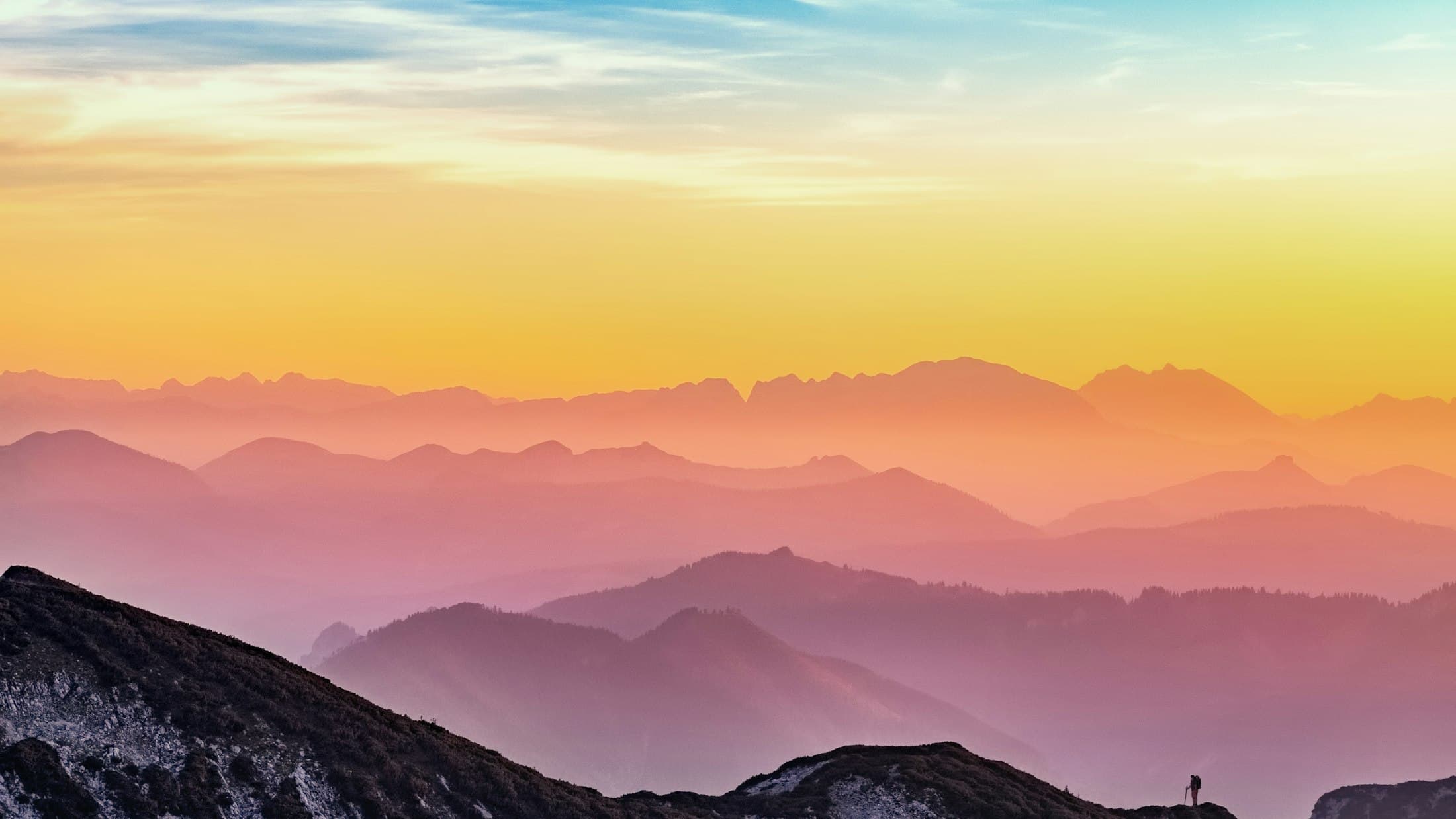 Layered mountain ridges glowing softly at sunrise